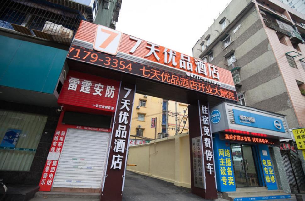 ein Gebäude mit Schildern an der Straßenseite in der Unterkunft 7Days Premium Yichang CBD Business Center Branch in Yichang