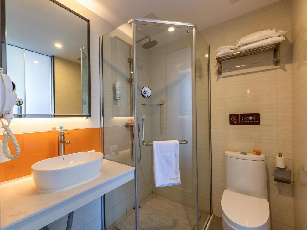 y baño con ducha, aseo y lavamanos. en 7Days Premium Xichang Torch Plaza Qionghai Wetland Park Branch, en Xichang