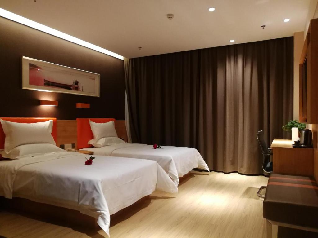 Habitación de hotel con 2 camas con arcos rojos. en 7Days Premium Anyang Tangyin Yuefei Temple Branch, en Anyang
