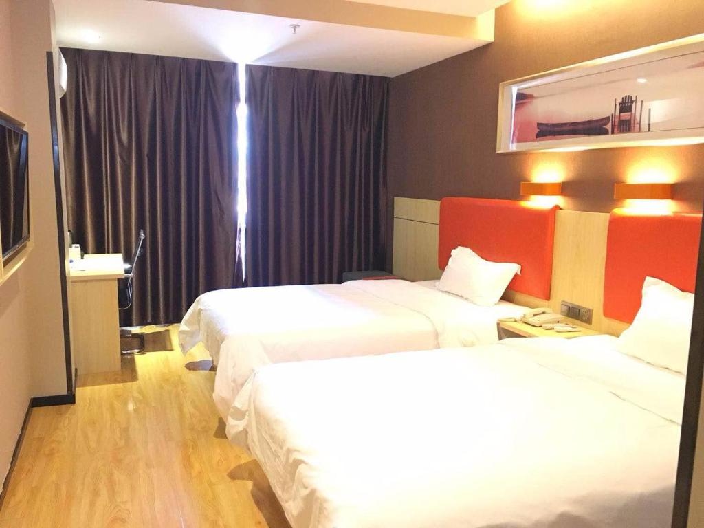 a hotel room with two beds and a television at 7Days Premium Fuzhou Dongxiang High Speed Railway Station Branch in Fuzhou