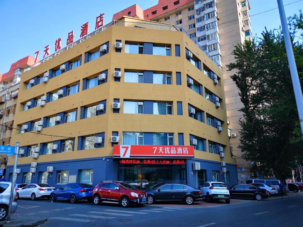 un gran edificio con coches estacionados frente a él en 7Days Premium Dalian Xinghai Square Xi'an Road Subway Station Branch, en Dalian
