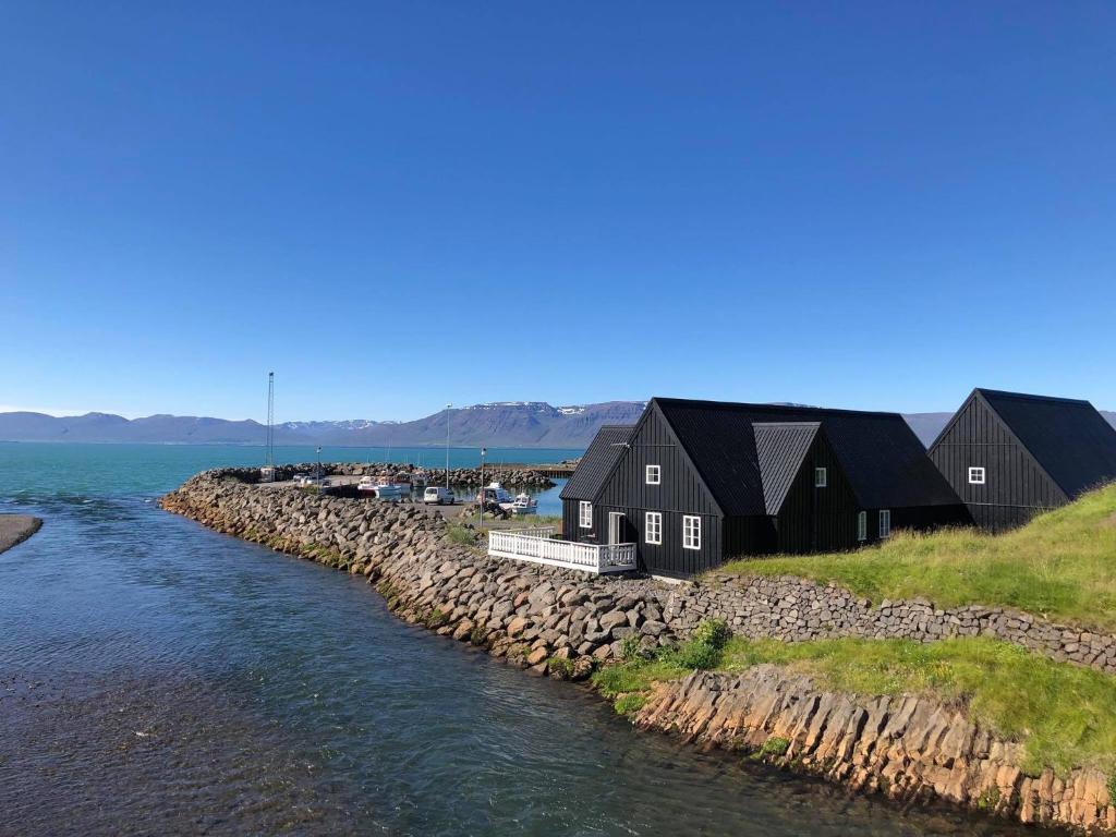 une rangée de maisons sur la rive d'une masse d'eau dans l'établissement Fraendgardur, à Hofsós