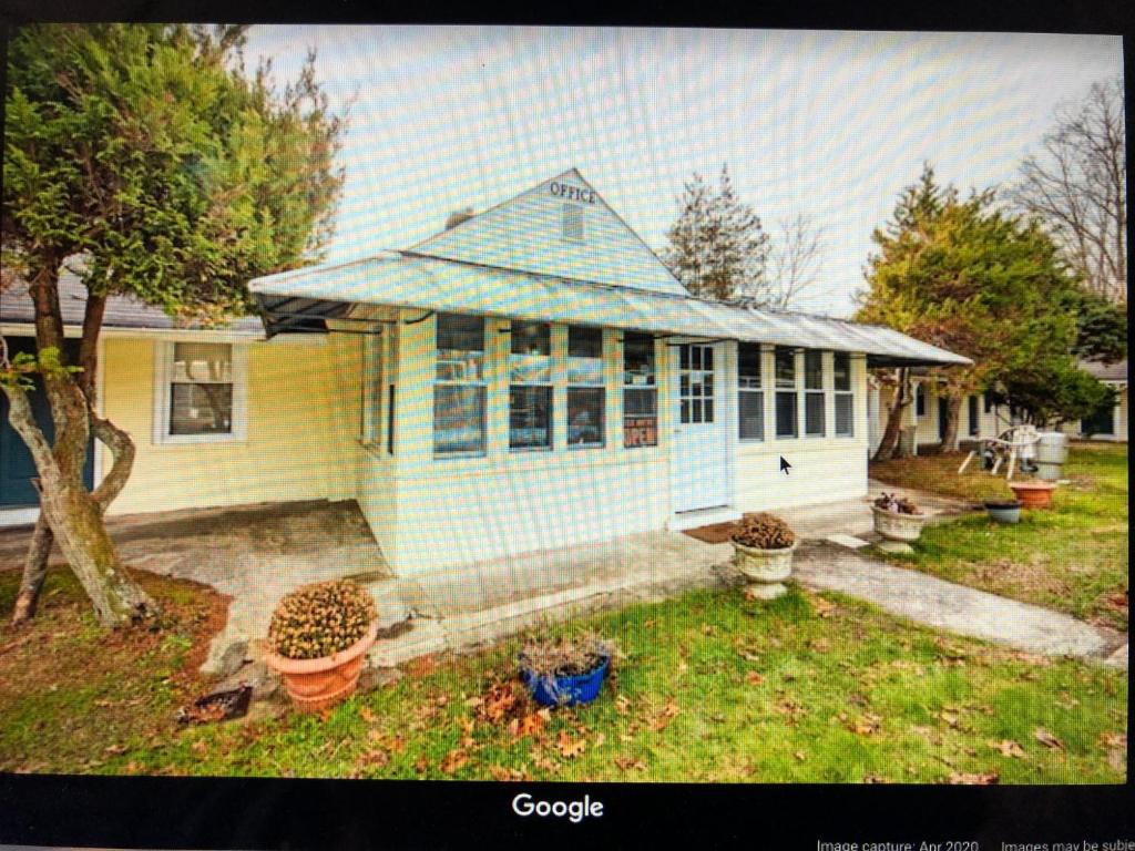 a blue and yellow house with a yard at Monmouth OYO in Neptune City