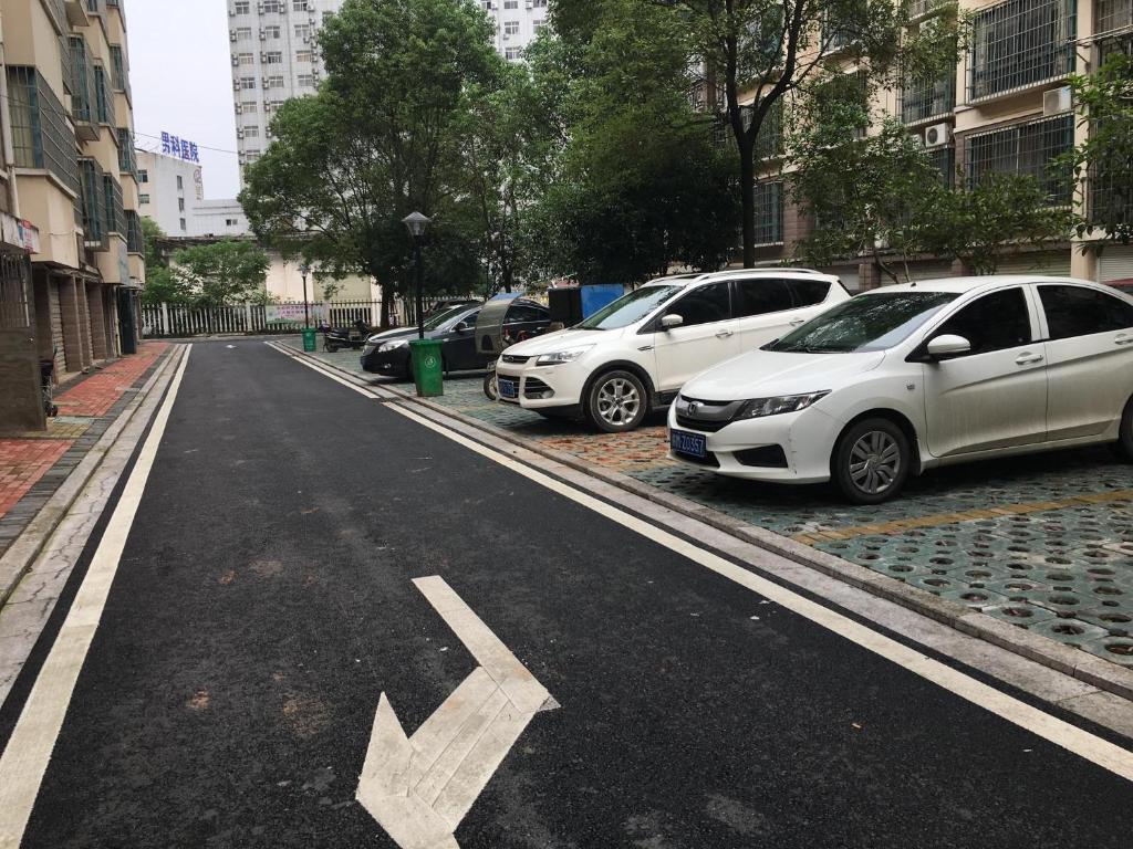 an empty street with cars parked in a parking lot at 7Days Premium Ji'an Taihe Gongnongbing Avenue Branch in Ji'an