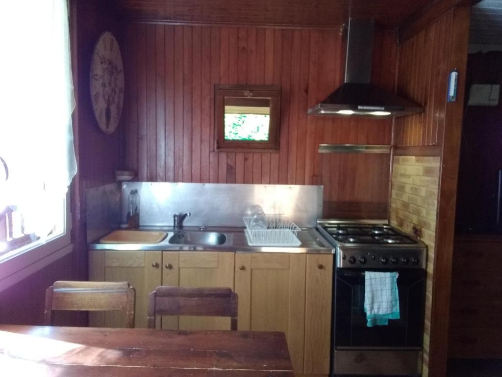 a kitchen with a stove and a sink at Chalet Vintage in Pollieu