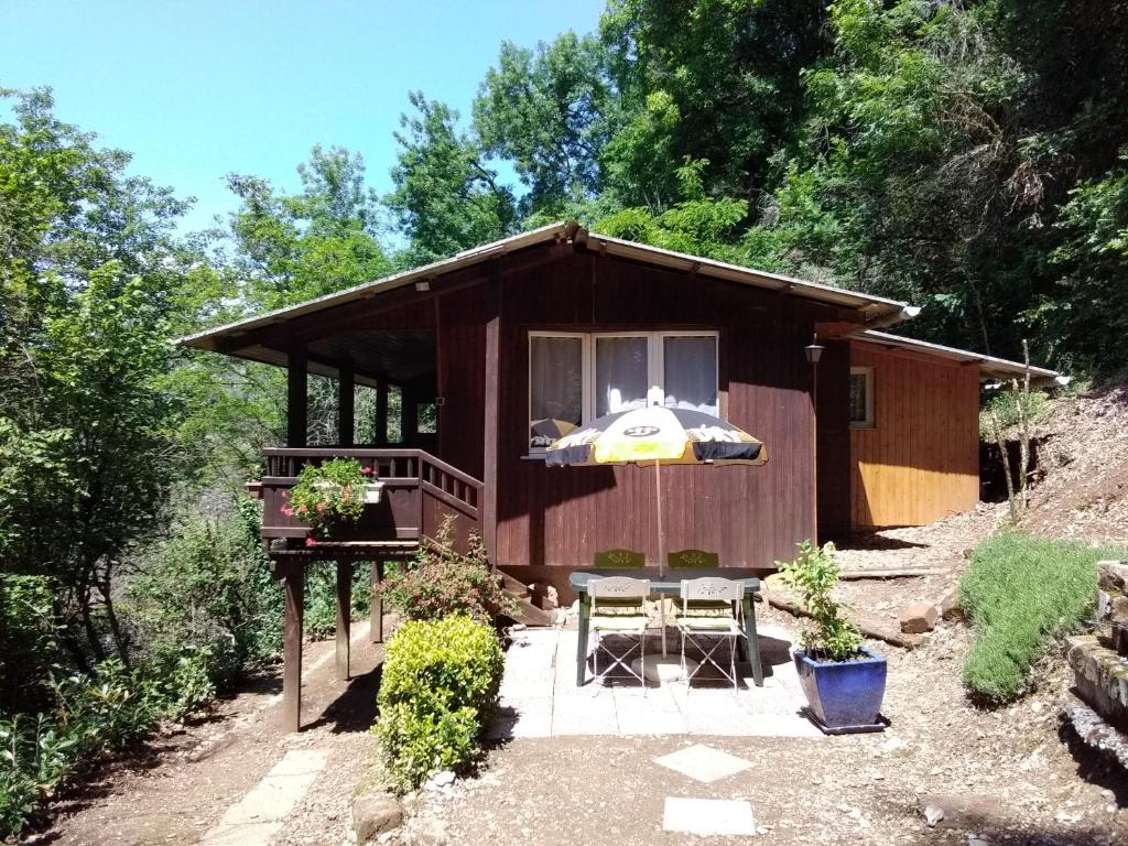 a small cabin with a table and an umbrella at Chalet Vintage in Pollieu