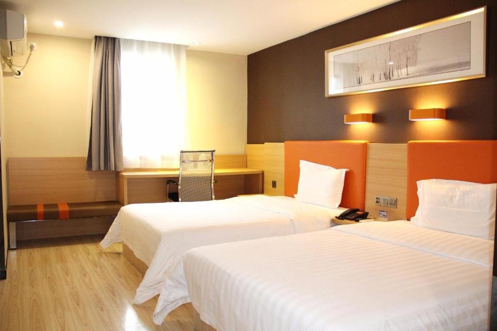 海口市にある7Days Premium Haikou Pearl Plaza Wuzhishan Road Branchのベッドが2つと窓があるホテルの部屋