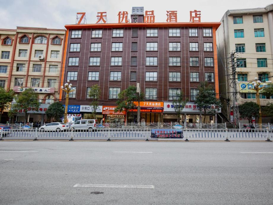 un gran edificio con una valla blanca delante de él en 7 Days Premium Zhaotong Zhenxiong Branch, en Zhenxiong