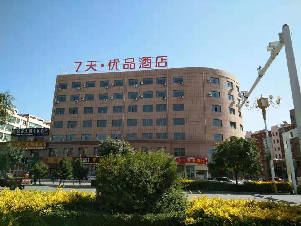 a building with a sign on top of it at 7Days Premium Shandan Center Plaza Branch in Zhangye