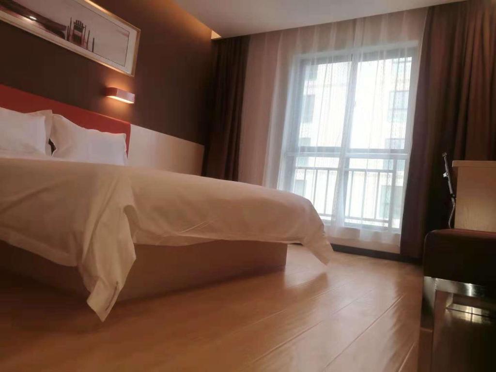 a bedroom with a bed with a large window at 7Days Premium Lanzhou New District Airport Branch in Lanzhou
