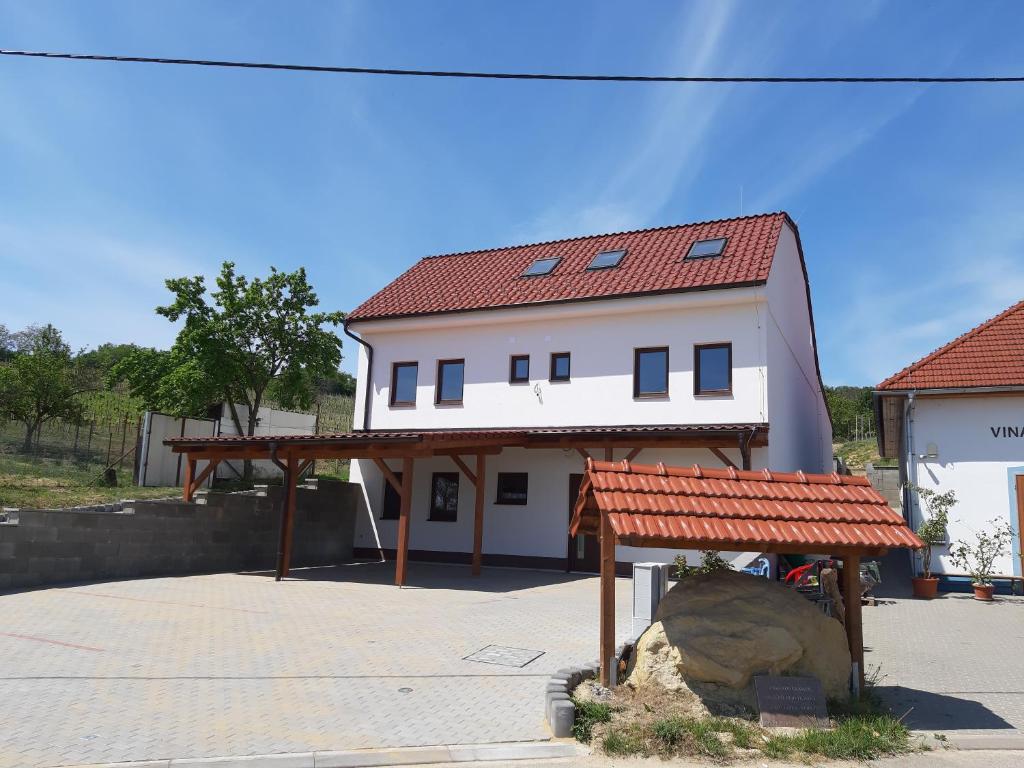 a large white house with a red roof at Penzion Třetí frejd in Bořetice