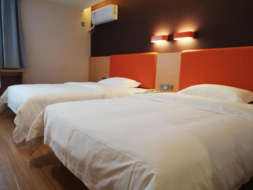 a group of three beds in a hotel room at 7Days Premium Changsha Dongtang Chigangchong Subway Station Branch in Changsha
