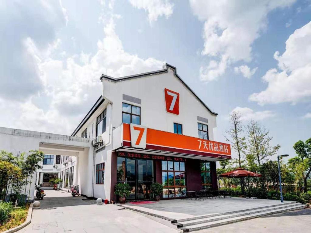 een wit gebouw met een rood bord erop bij 7Days Premium Longyan Liancheng Guanzhi Mountain Scenic Spot Branch in Wenheng