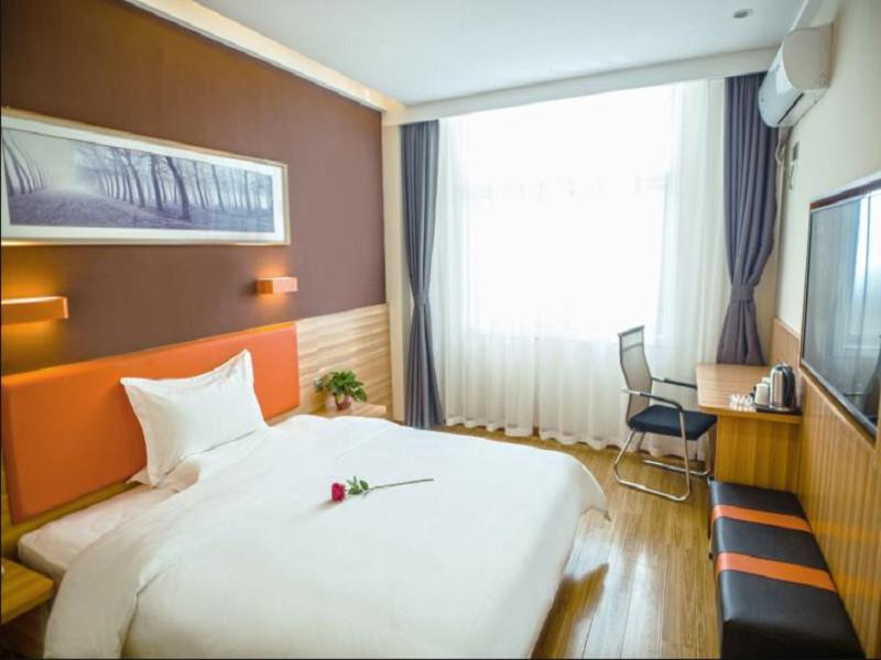 a large white bed in a room with a window at 7Days Premium Luoyang Yichuan Dukang Avenue Branch in Luoyang