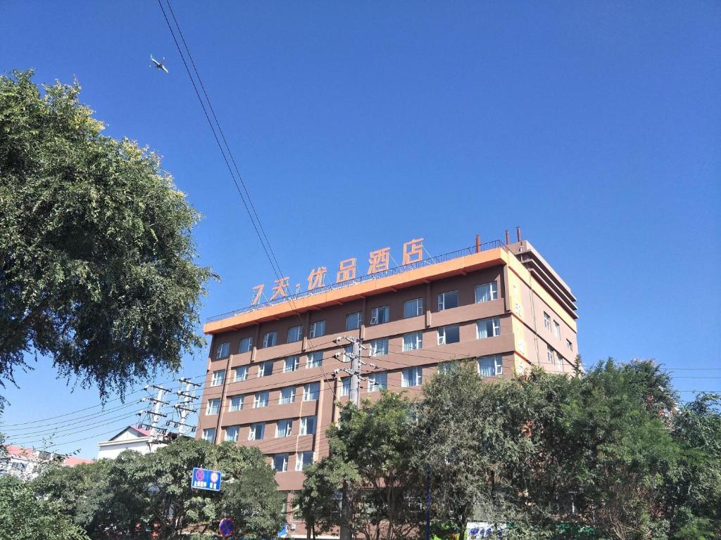 een gebouw met een bord erop bij 7Days Premium Xining Bayi East Road Tuanjie Bridge Branch in Xining