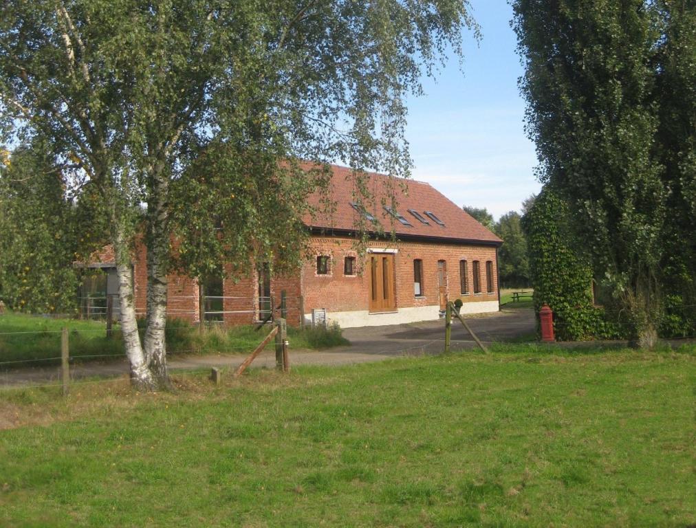 un grand bâtiment en briques avec un arbre devant lui dans l'établissement B&B D'Hollehoeve, à Heist-op-den-Berg