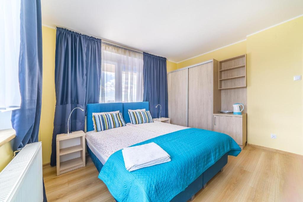 a bedroom with a blue bed and a window at Morski Diament in Władysławowo