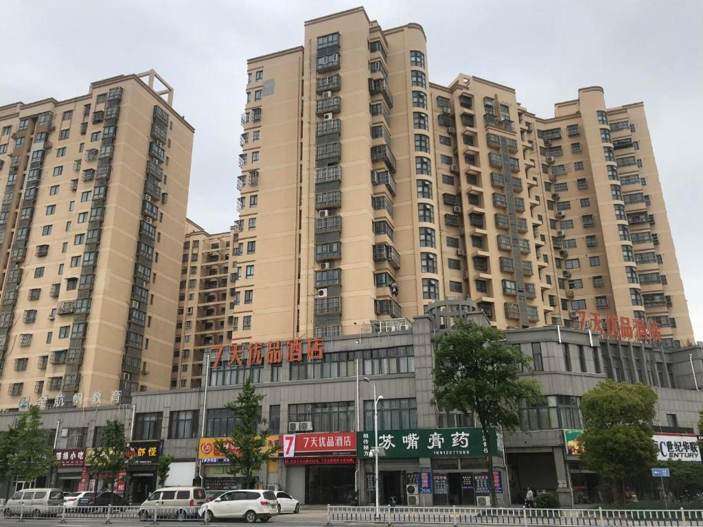 um grande edifício de apartamentos com carros estacionados em frente em 7Days Premium Huai'an Hexia Ancient Town Zhou Enlai Former Residence Branch em Hexia