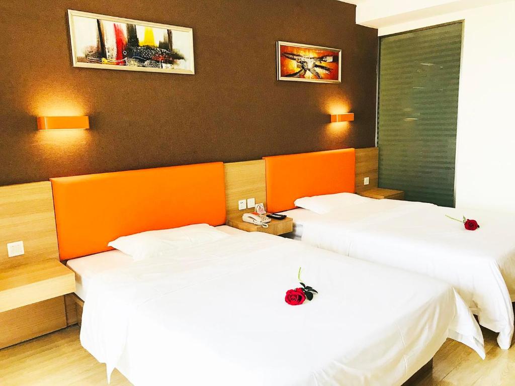 2 letti in camera d'albergo con lenzuola bianche di 7Days Premium Chengdu Pi County Xiqu Avenue Branch a Chengdu