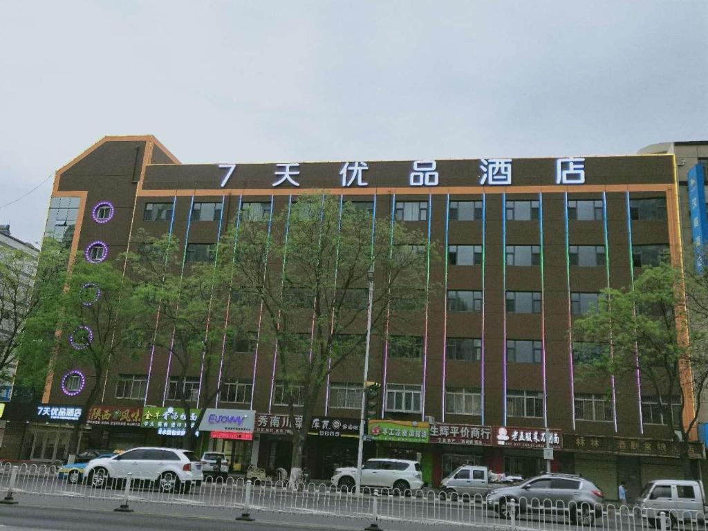 a large building with cars parked in front of it at 7Days Premium Yinchuan High Speed Railway Station Train Station Branch in Yinchuan