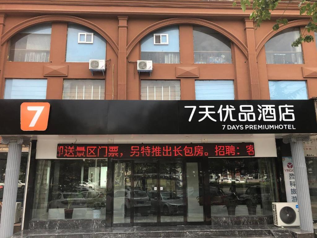 un edificio con una señal delante de él en 7Days Premium Jiyuan Tiantai Road Xinyao City Square Branch, en Jiyuan
