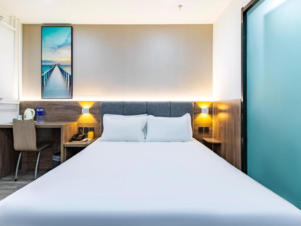 Säng eller sängar i ett rum på 7Days Premium Tianjin Development Zone Fourth Avenue Taida Branch