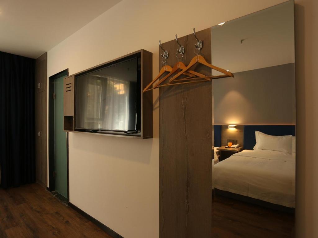 una camera con letto e TV a parete di 7Days Premium Xi'ning Dashizi Center Branch a Xining