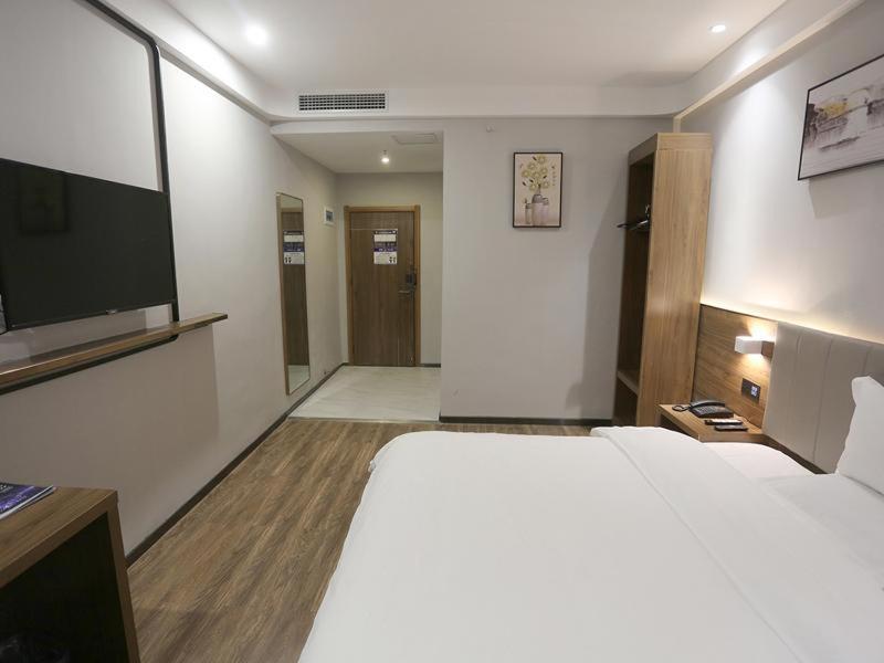 a bedroom with a large bed and a flat screen tv at 7Days Premium Zhumadian Tianzhongshan Avenue Branch in Zhumadian