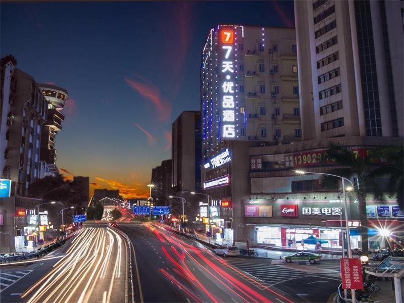 Una calle concurrida de noche con coches en 7 Days Premium Jiangmen Diwang Plaza Branch en Jiangmen