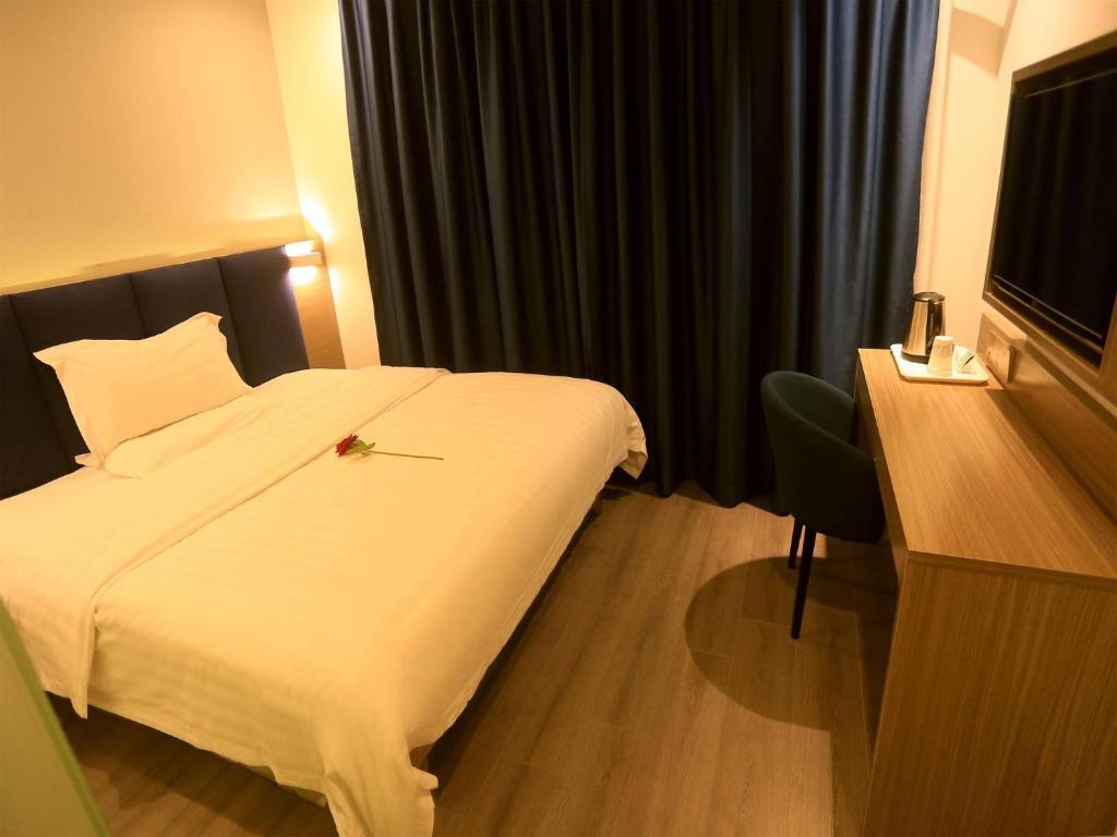 a hotel room with a white bed and a desk at 7Days Premium Shenzhen High Speed Rail North Station Minzhi Branch in Shenzhen