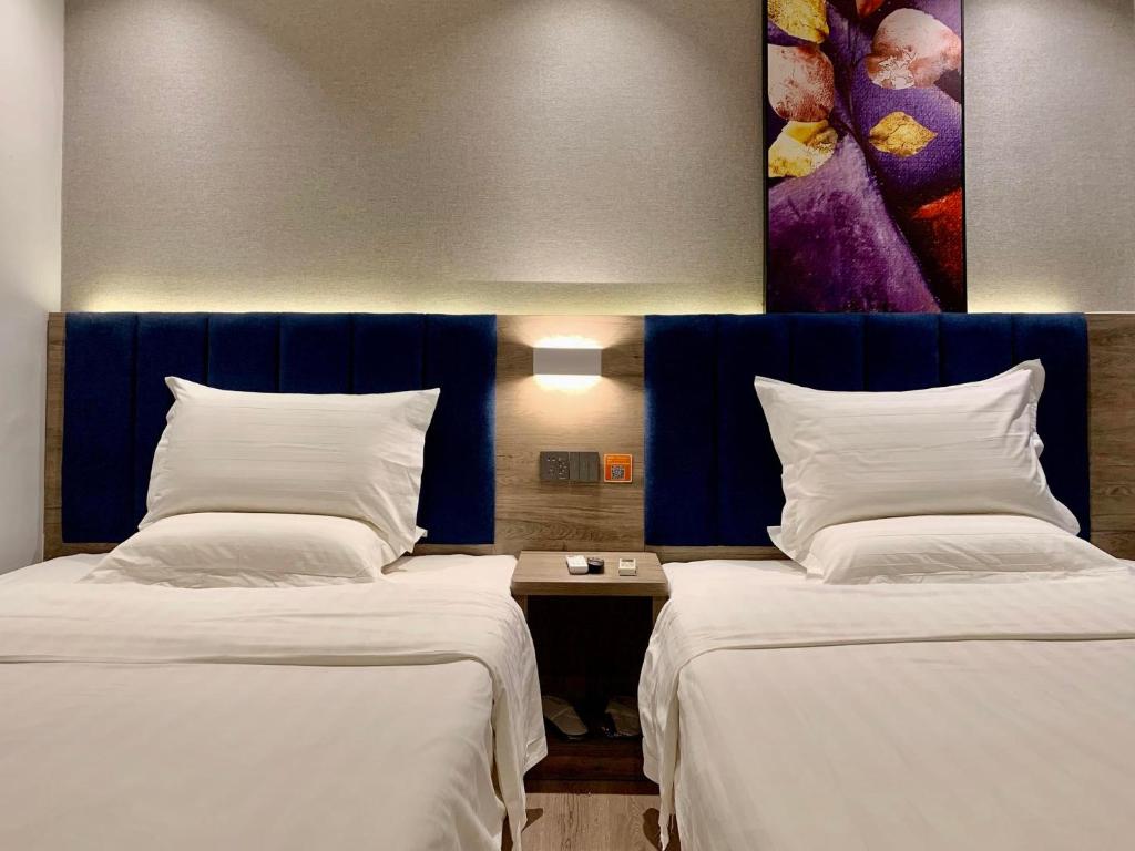 2 Betten nebeneinander in einem Zimmer in der Unterkunft 7Days Premium Guangzhou Guangyuan Coach Station Branch in Guangzhou