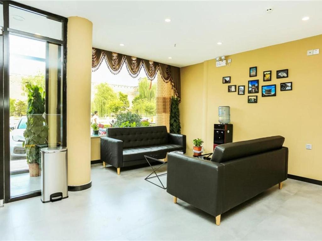 - un salon avec deux canapés noirs et une fenêtre dans l'établissement 7Days Premium Jinzhong Pingyao Ancient City West Gate Branch, à Pingyao