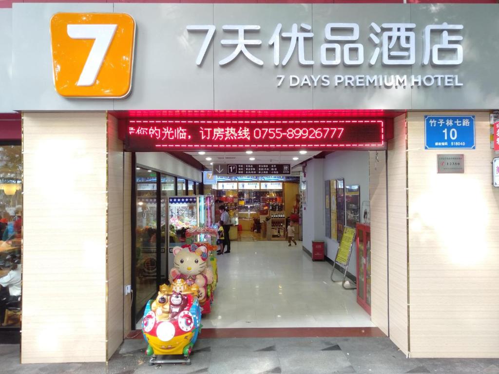una entrada a la tienda con un cartel que lee días hotel pingüino en 7Days Premium Shenzhen Zhuzilin Subway Station en Shenzhen