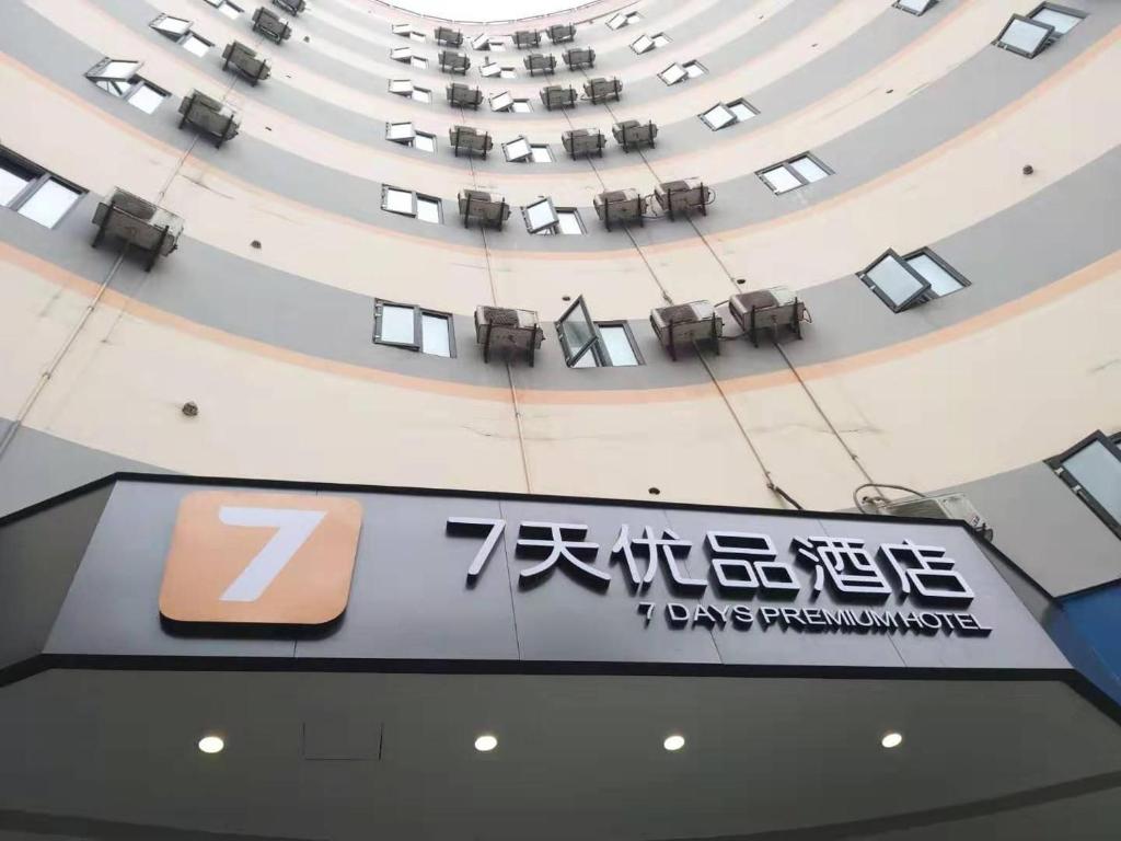 um edifício com uma placa no meio em 7Days Premium Yibin North Gate Bus Station Branch em Yibin