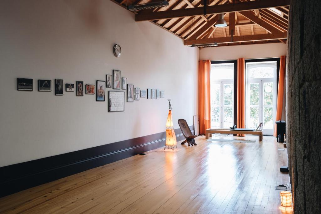 a room with a wooden floor and a large window at Casa do Ser Hostel in Viana do Castelo