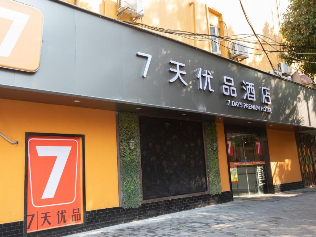 un edificio con un cartello sul lato di 7Days Premium Shanghai Xujiahui Longhua Road Subway Station Branch a Shanghai
