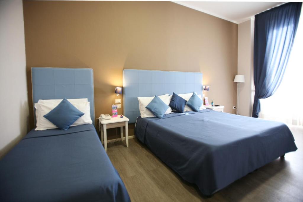 En eller flere senger på et rom på Hotel Magenta