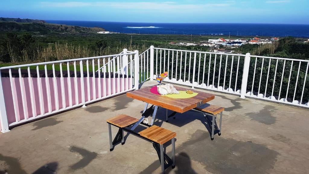 een picknicktafel op een balkon met uitzicht op de oceaan bij The Music House in Praia da Vitória