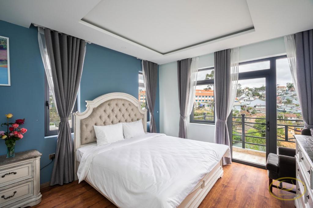 1 dormitorio con cama blanca y ventana grande en Hong Mon Villa en Dalat
