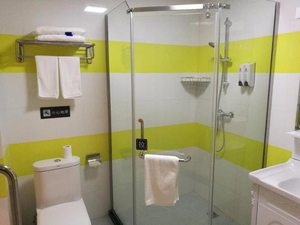 a bathroom with a shower with a toilet and a sink at 7Days Inn Danyang Train Station Wuyue Square Branch in Zhenjiang