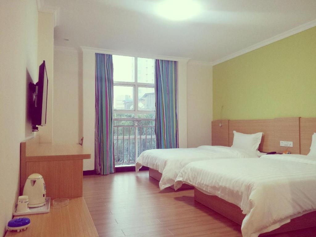 a hotel room with two beds and a window at 7 Days Inn Foshan Pingzhou Jade Street Branch in Foshan