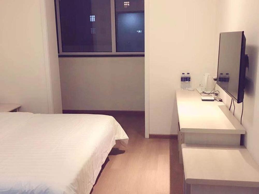 Habitación de hotel con cama y TV en 7 Days Inn Tianjin Jiaotong University Caozhuang Subway Station Branch en Tianjin