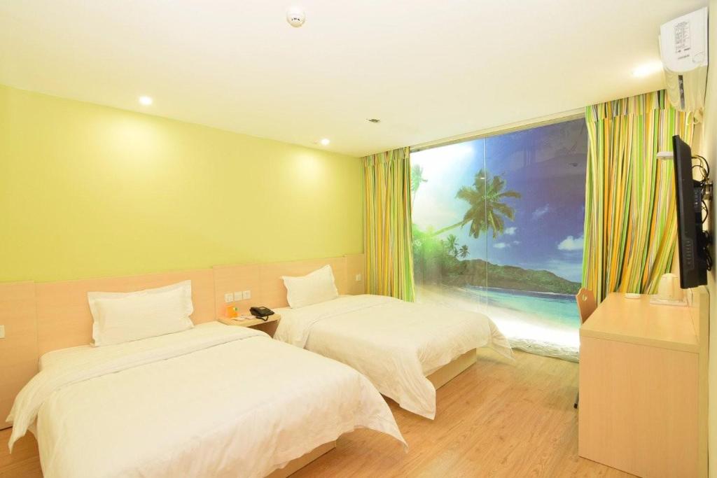 two beds in a room with a view of the ocean at 7Days Inn Luoyang Xin'an Branch in Luoyang