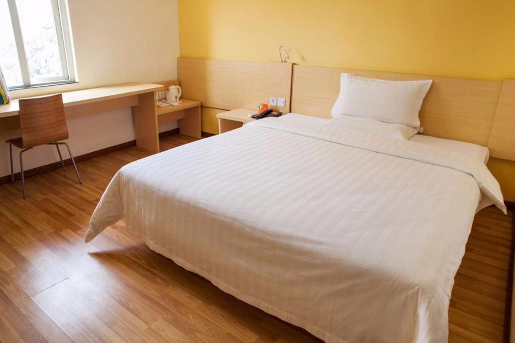1 cama blanca grande en una habitación de hotel en 7Days Inn Yibin Boxi City Center Branch, en Yibin