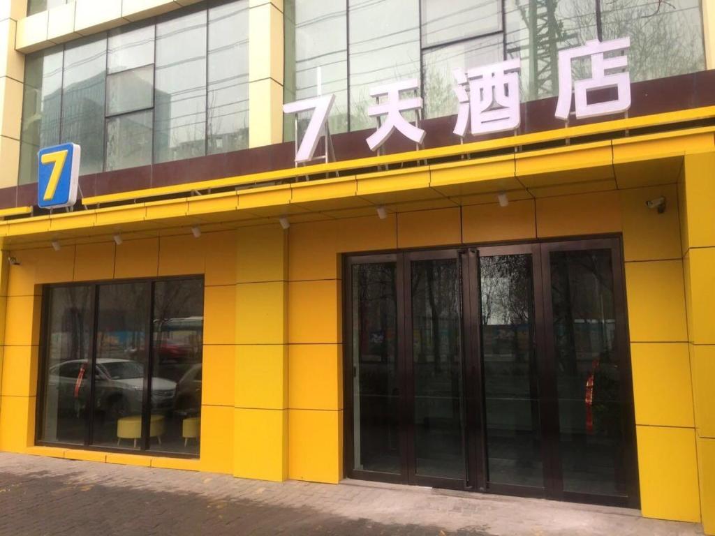 un edificio amarillo con un cartel encima en 7 Days Hotel Urumqi Kashgar East Road Normal University Branch, en Ürümqi