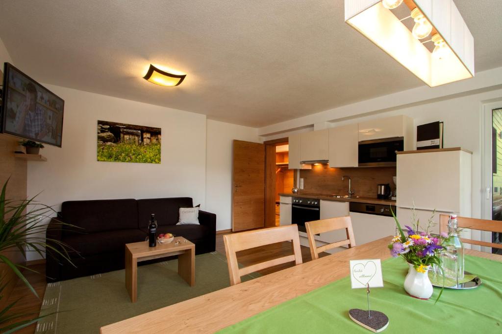 察姆斯的住宿－耶恩公寓，客厅以及带桌子和沙发的厨房。