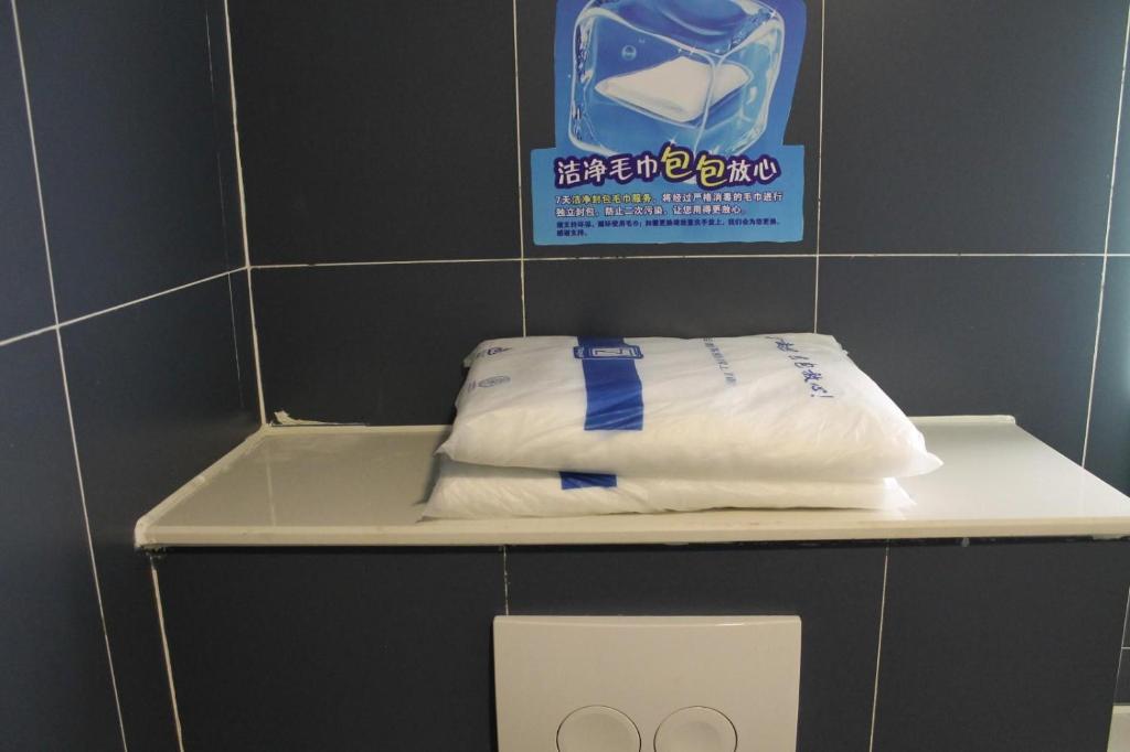 a pair of towels sitting on a shelf in a bathroom at 7 Days Hotel Ziyang Songtao Road Branch in Ziyang