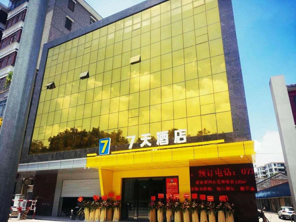 a building with a bunch of flowers in front of it at 7Days Inn Foshan Pingzhou Jade Street East Gate Branch in Guangzhou