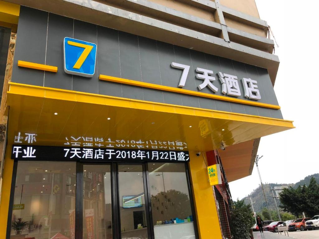 un magasin avec un panneau sur le côté d'un bâtiment dans l'établissement 7Days Inn Rongjiang Binjiang Avenue Branch, à Yung-chiang