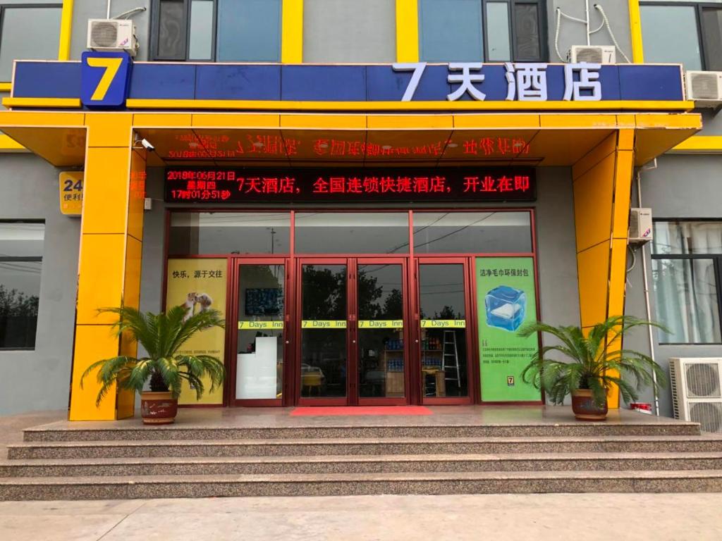 un edificio con una puerta roja y azul y escaleras en 7Days Inn Wuan Bus Station Branch, en Handan